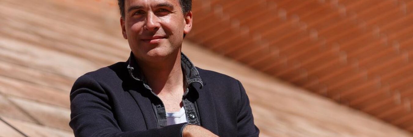 Trajectoire - Rencontre avec Guillaume Séverac-Schmitz | Portrait du metteur en scène, sur un fond de brique rouge